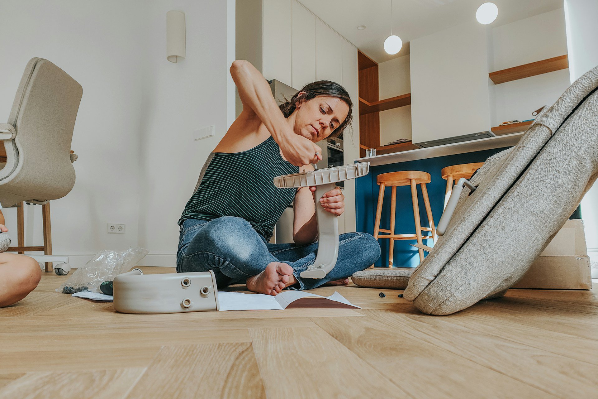 Ženska sestavlja stol po navodilih – praktični nasveti za hišna popravila in montažo pohištva