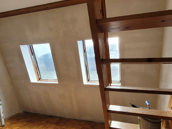 Popleskana stena v mansardi v belo barvo