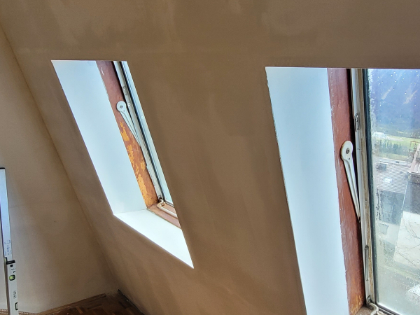 Popleskana stena v mansardi v belo barvo