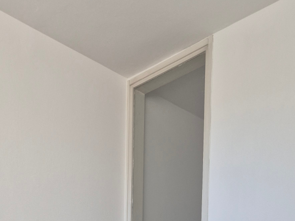 Popleskana stena v mansardi v belo barvo