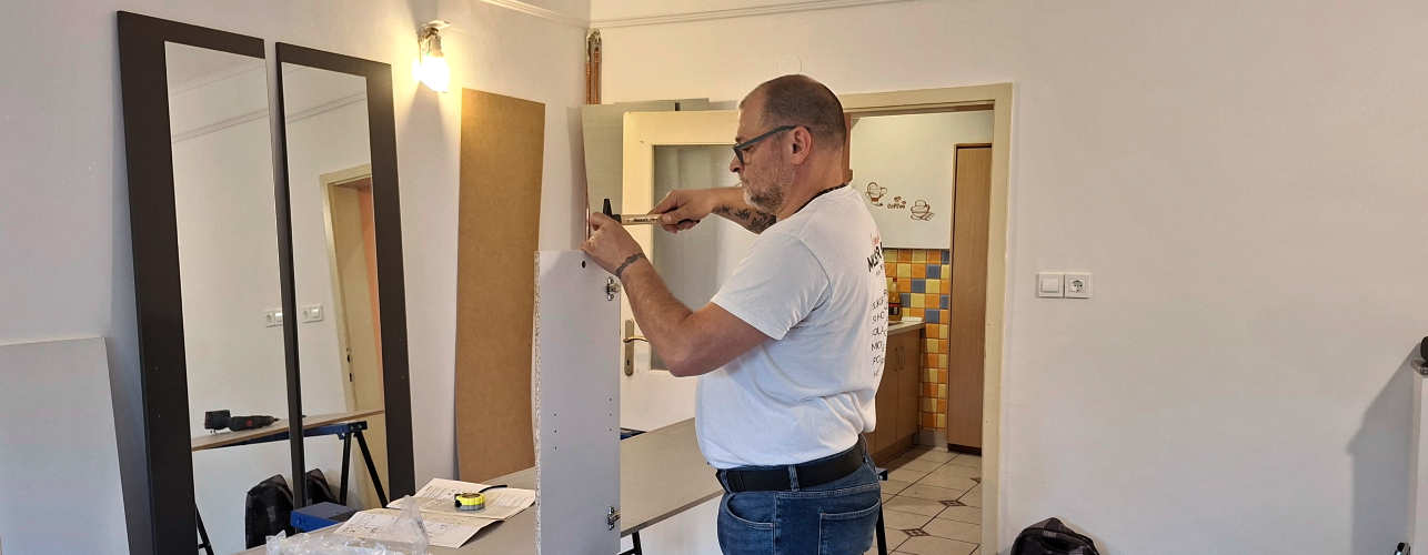 Mojster Neno pri montaži garderobne omare Lesnina za spalnico